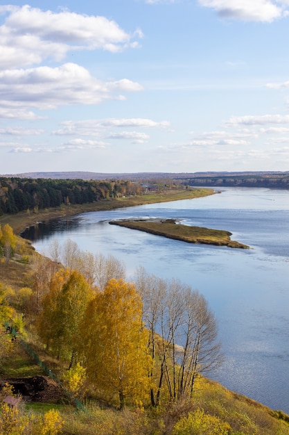 Beautiful wide river in the autumn forest in a quiet and peaceful place Reflection of the sky