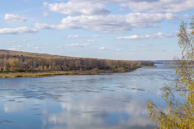 Beautiful wide river in the autumn forest in a quiet and peaceful place