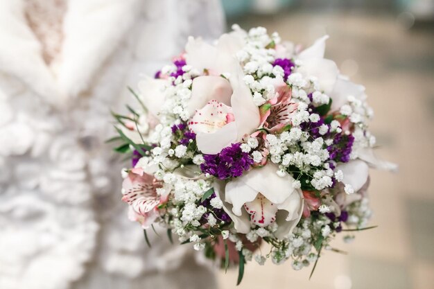 Beautiful winter bridal bouquet with orchid and violet eustoma freesia