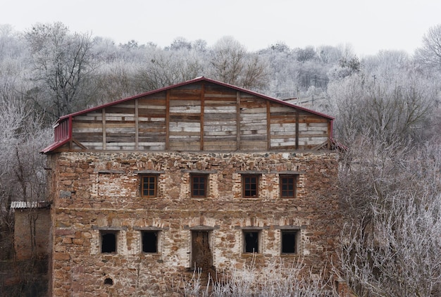 Beautiful winter landscape with abandoned buildings of water mill over the mountain tikich river