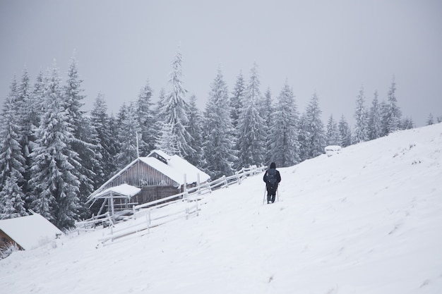 Beautiful winter mountain landscape. Cabin in the mountains in winter. Winter landscape with fresh snow in a mountain forest.