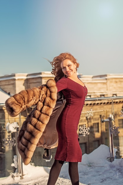 Beautiful winter woman in coat enjoying winter sun outdoor