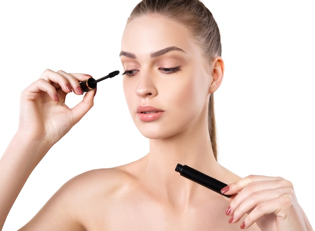 Beautiful woman applying mascara on her eyelashes