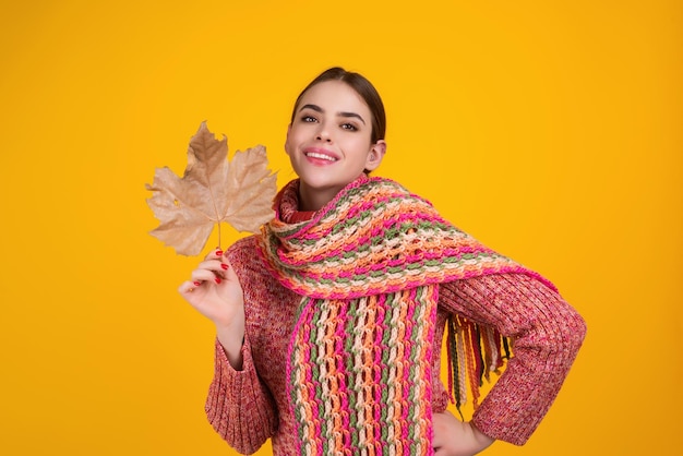 Beautiful woman in autumn clothes hold falling leaves posing in studio gorgeous brunette model girl