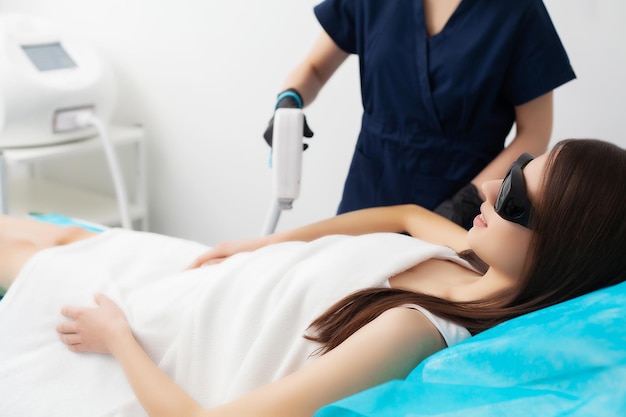 Beautiful woman in beauty studio getting laser hair removal procedure