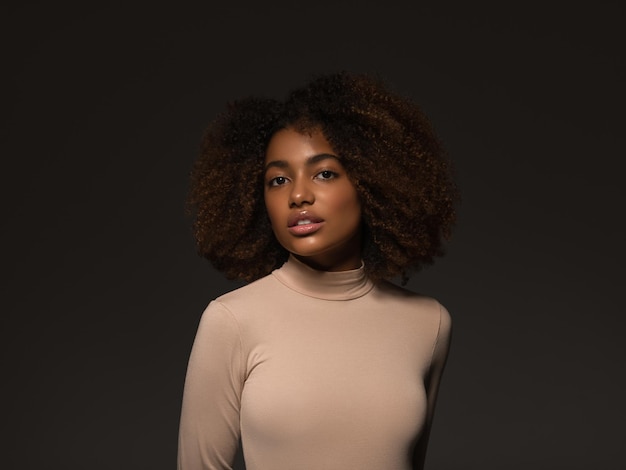 Beautiful woman black skin pretty african american beautiful model in sweater on black background.