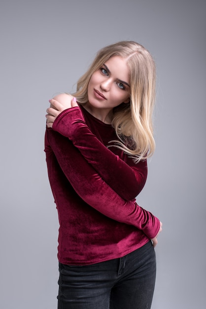 Beautiful woman blond full length portrait young studio on gray in black jeans