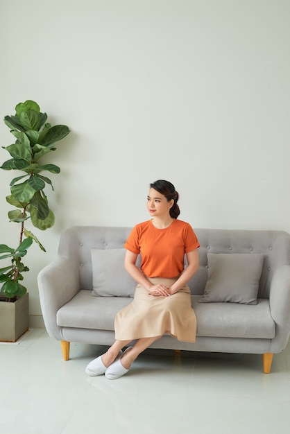 Beautiful woman in casual clothes sitting on a sofa