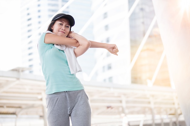 Beautiful woman  cool down after work out with white towel during sunset