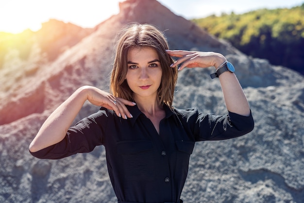 Beautiful woman in coveralls posing for the camera in the sand quarry, summertime