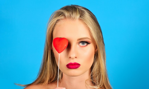 Beautiful woman covering eye with red heart valentines day love relationships closeup portrait