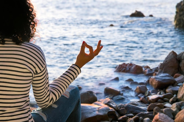 Beautiful woman doing yoga at the beach