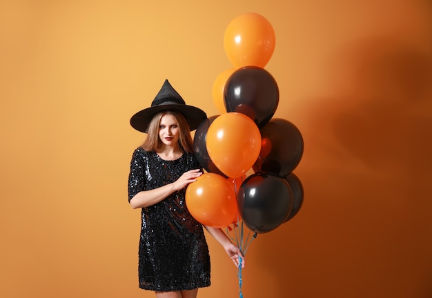 Beautiful woman dressed as witch for Halloween on color