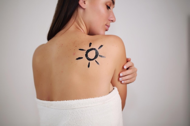 Beautiful woman dressed in a towel on the back of the sun