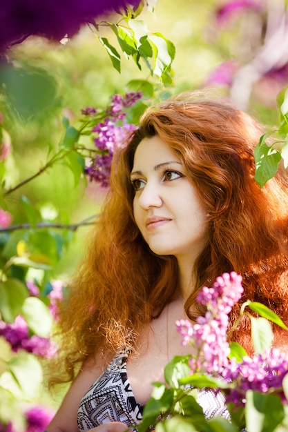 Beautiful woman enjoying lilac garden