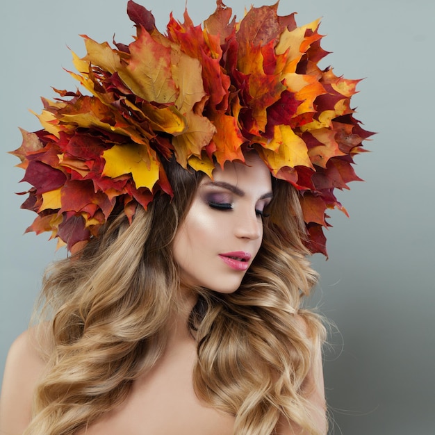 Beautiful woman face Pretty model with makeup and autumn leaves crown