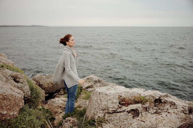 Beautiful woman freedom walk on the stone coast Relaxation concept