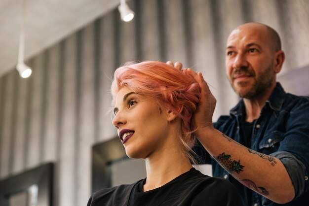 Beautiful woman getting haircut by hairdresser in the beauty salón.