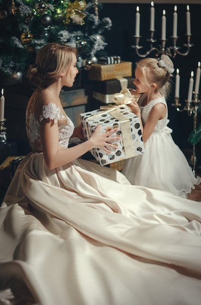 Beautiful woman giving present to little girl