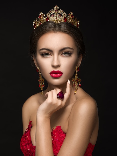 Beautiful woman in a golden crown and earrings