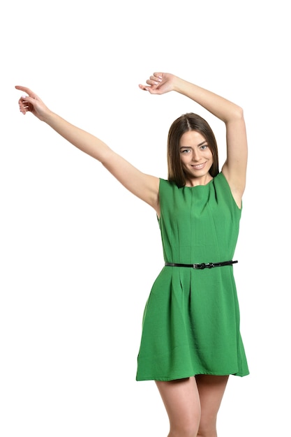 Beautiful woman in green dress with hands up on white background