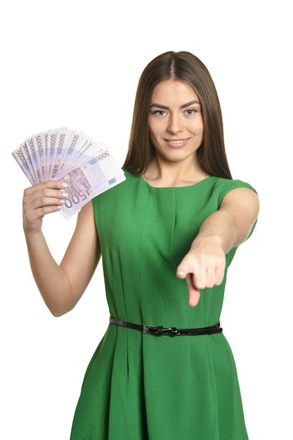 Beautiful woman in green dress with money on white background