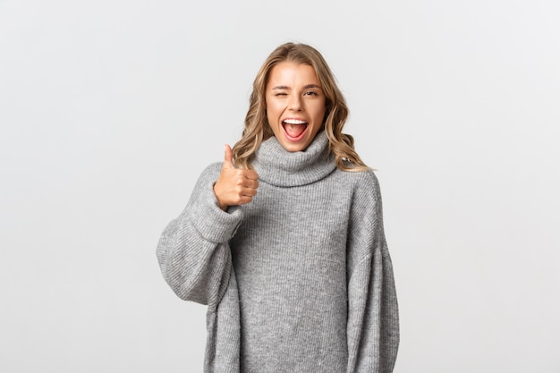 Beautiful woman in a grey sweater posing