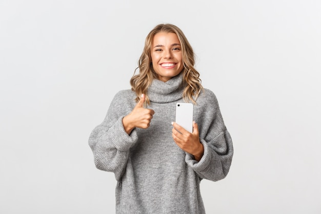 Beautiful woman in a grey sweater posing