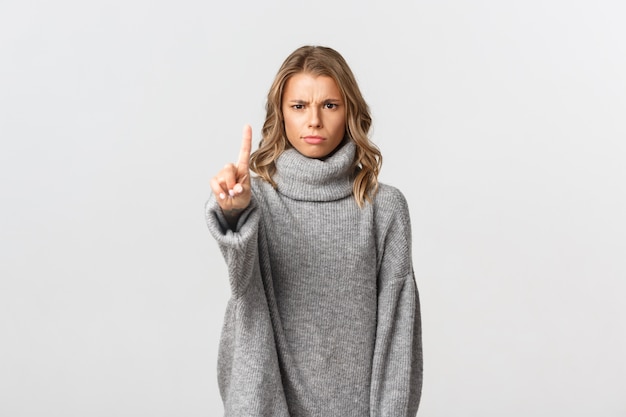 Beautiful woman in a grey sweater posing