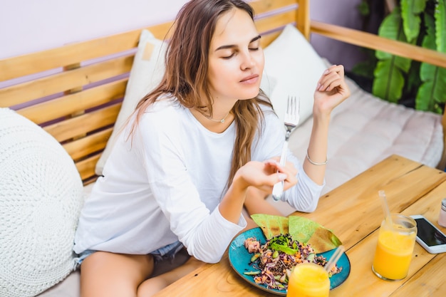 A beautiful woman has breakfast in a stylish cafe