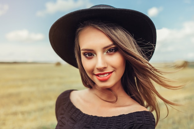 Beautiful woman in hat on the meadow