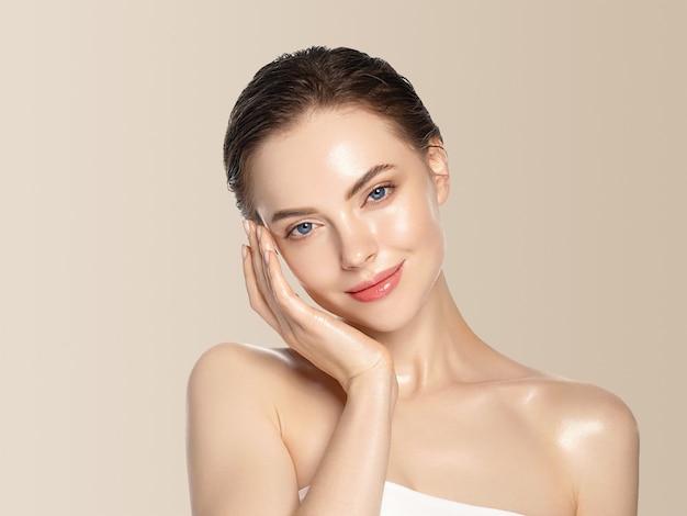 Beautiful woman healthy skin care concept portrait with hands close up beige background. Studio shot