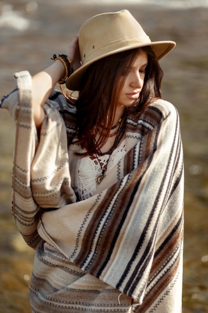 Beautiful woman hipster portrait wearing hat and poncho stylish outfit boho travel concept sensual look