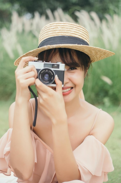 Beautiful woman hold vintage camera at garden