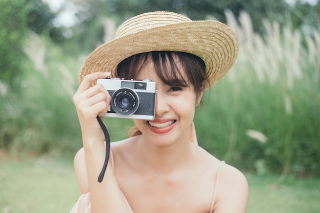 Beautiful woman hold vintage camera at garden