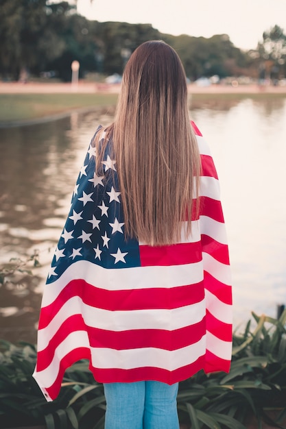 Beautiful woman holding American flag - image