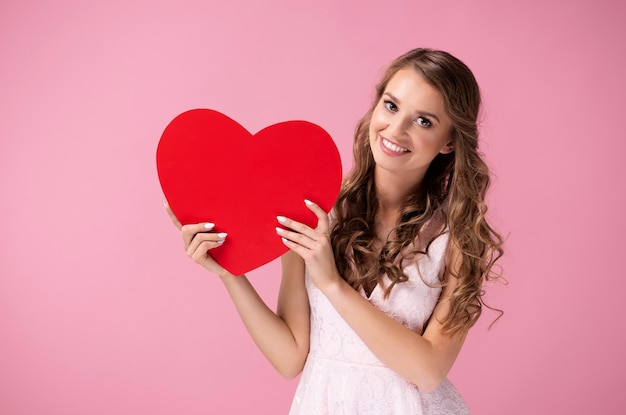 Beautiful woman holding a big, red heart