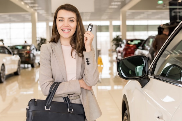 Beautiful Woman Holding Car Keys in Showroom