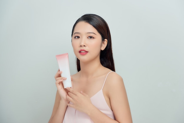 Beautiful woman holding a cream tube product