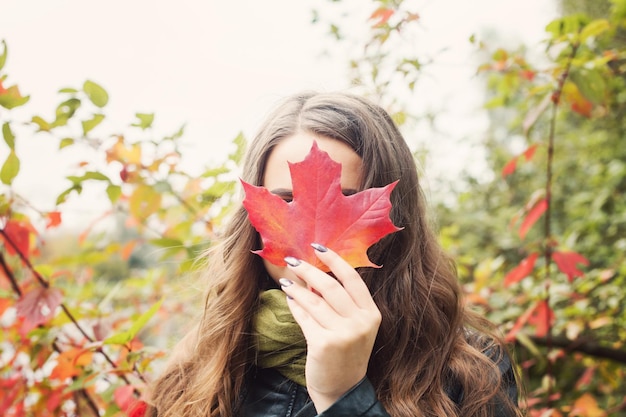 Beautiful woman holding fall leaf autumn concept