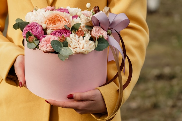 Beautiful woman holding pink box with flowers. Gift to Women's Day. 