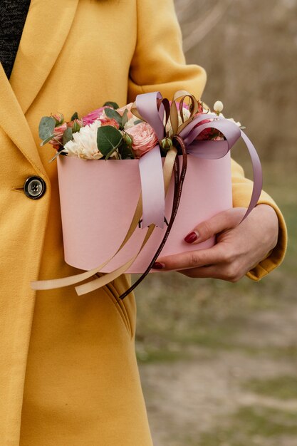 Photo beautiful woman holding pink box with flowers. gift to women's day. 