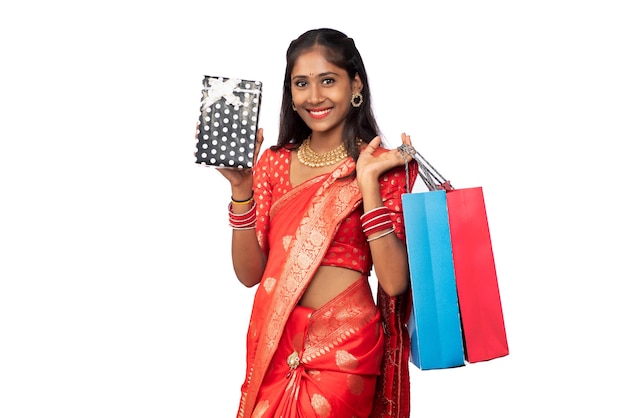 Beautiful woman holding shopping bags and gift Box on a white background