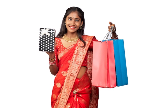 Beautiful woman holding shopping bags and gift Box on a white background