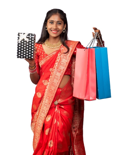 Beautiful woman holding shopping bags and gift Box on a white background