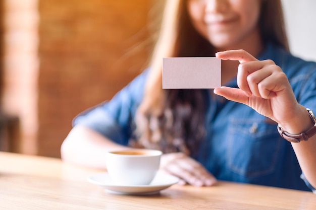 A beautiful woman holding and showing a blank empty business card to someone