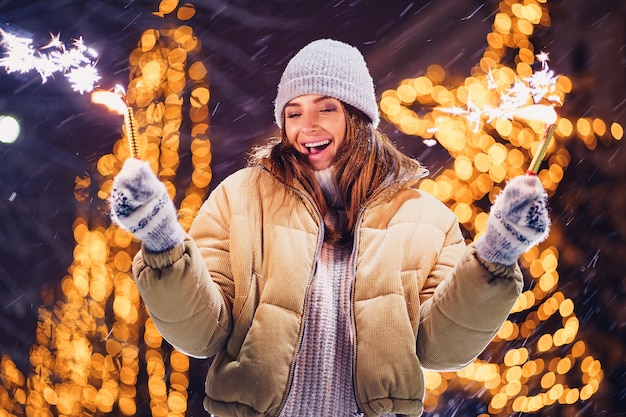 Beautiful woman holding sparkles and have fun in the open air