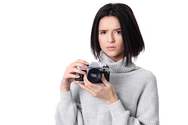 Beautiful woman holding a vintage camera isolated over white background