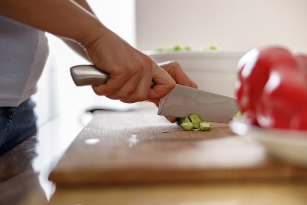 Beautiful woman is cooking delicious dishes at her home kitchen