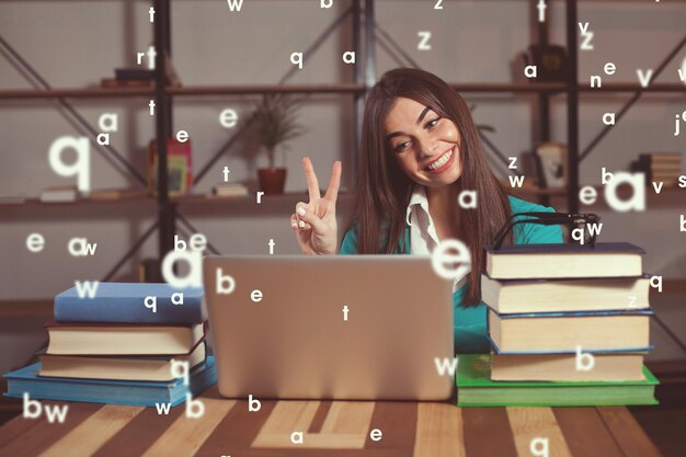 Beautiful woman is happy about her successful work with laptop at the  table